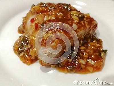 Sweet chilli spicy fish Thai style on white plate Stock Photo