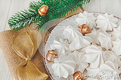 Sweet christmas background with airy meringues ,fir branch,golden acorns and knot Stock Photo