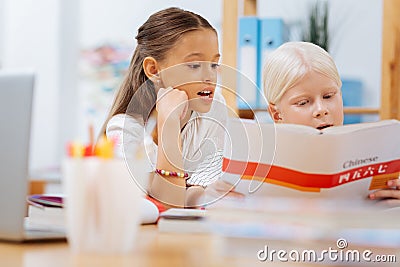 Sweet clever children spending time on studying Stock Photo