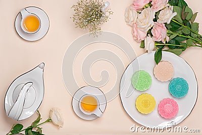 Sweet color of snow skin mooncake. Traditional mid autumn festival foods with tea on table setting. Stock Photo