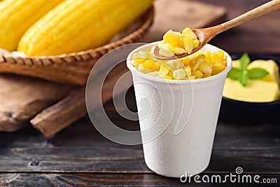 Sweet corn with butter in a biodegradable cup eating by spoon Stock Photo