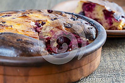 Sweet cottage cheese casserole with red cherry and semolina on wooden table. Ceramic bowl with baked cottage cheese casserole , Stock Photo