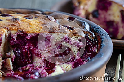 Sweet cottage cheese casserole with red cherry and semolina on wooden table. Ceramic bowl with baked cottage cheese casserole , Stock Photo
