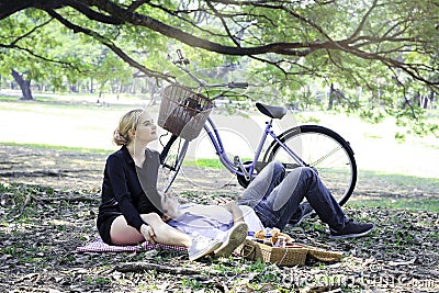 Sweet couple relaxing on picnic in park man lay down on his girlfriendâ€™s lap young beautiful lover spending time together and Stock Photo