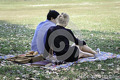 Sweet couple relaxing on picnic in park young beautiful lover spending time together and having romantic moment in summer garden Stock Photo