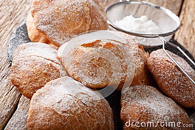 Sweet deep-fried Bunuelos sprinkled with powdered sugar close-up. horizontal Stock Photo