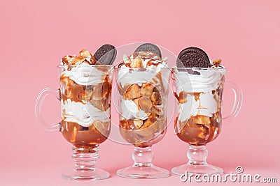 Sweet dessert in glass with biscuit and whipped cream on pink bsckground, selective focus and blank space Stock Photo