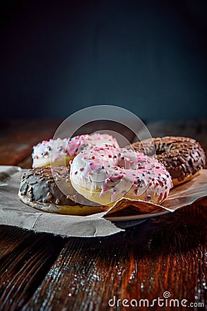 Sweet donut with topping laid on a rustical wooden table Stock Photo