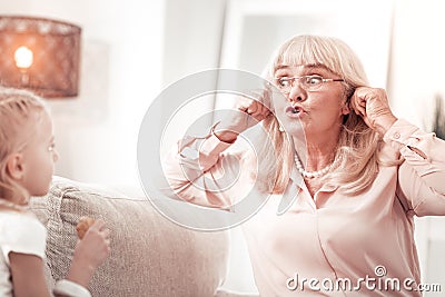 Sweet elegant grandmother in eyeglasses looking funny Stock Photo