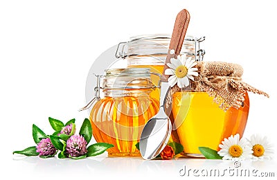 Sweet honey in glass jar with spoon and flowers Stock Photo