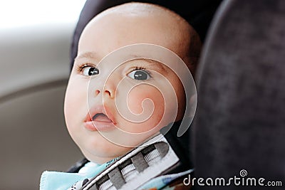 Sweet infant in the car sits in a child seat. Safe driving. Baby care Stock Photo