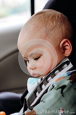 Sweet infant in the car sits in a child seat. Safe driving. Baby care Stock Photo