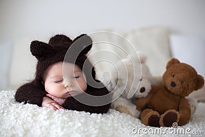 Sweet little baby boy, dressed in handmade knitted brown soft te Stock Photo