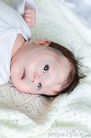 Sweet little baby daughter on white woolen blanket Stock Photo