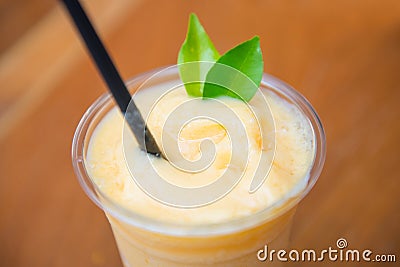 Sweet mango smoothie in plastic cup Stock Photo