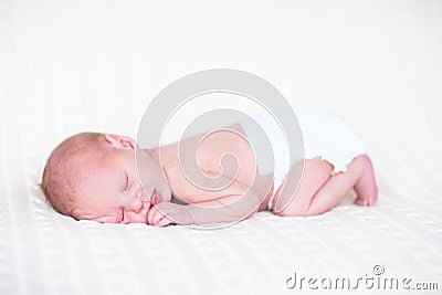 Sweet newborn baby sleeping wearing a diaper Stock Photo