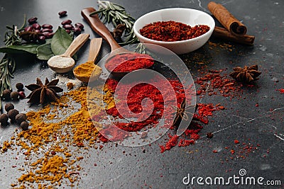 Sweet pepper lies on a small plate, scattered spices on a dark background star anise, cinnamon, textured wood Stock Photo