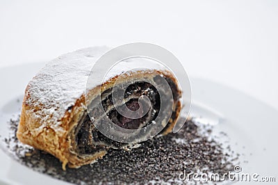 Sweet poppy strudel with powder sugar on white plate, product photography for bakery or patisserie Stock Photo