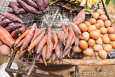 Sweet potato and egg grilled on stove in countryside store.Thailand Stock Photo