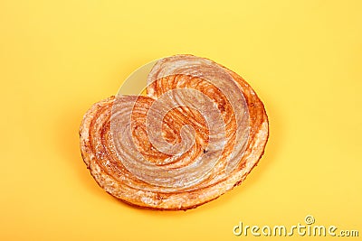 Sweet puff pastry on yellow background - Palmeras Stock Photo