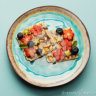 Sweet sandwiches peanut butter with fruits, berries with honey on a plate, top view. Stock Photo