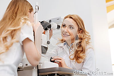 Sweet skillful ophthalmologist giving her patient instructions Stock Photo