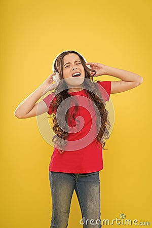 Sweet song so start the music. Cute song singer on yellow background. Little girl singing song playing in headphones Stock Photo