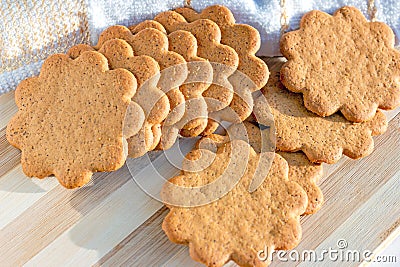 Sweet Swedish almond thins with ginger and cinnamon (Pepparkaka or Pepparkakor biscuits) on light wooden background. Stock Photo