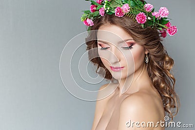 Sweet sweet beautiful young girl with a wreath of flowers on his head with bare shoulders with beauty makeup soft pink lips Stock Photo