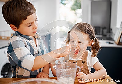 Sweet, sweet revenge. a little girl and boy having fun while baking together at home. Stock Photo