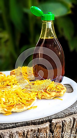 Sweet syrup / honey and salty cheese on round pancakes / flapjacks for breakfast or brunch. Stock Photo