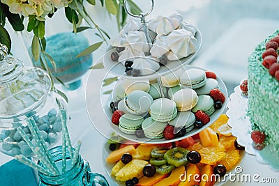 Sweet table with colorful macaroons, fruits and cake Stock Photo