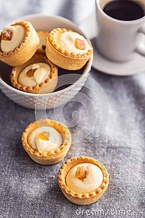 Sweet tarlets. Tasty mini tarts. Mini pie with cream on kitchen table Stock Photo