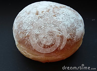 Big fluffy donut over black table. Sweet and tasty, just delicious! Stock Photo