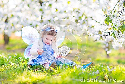 Sweet toddler girl in fairy costume in fruit apple garden Stock Photo