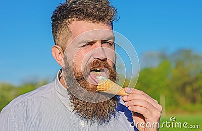 Sweet tooth concept. Bearded man with ice cream cone. Man with long beard licks ice cream. Man with beard and mustache Stock Photo