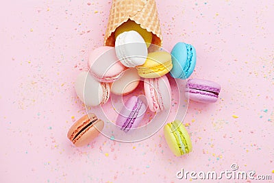 Sweet waffle cone with macaron or macaroon on pink pastel background top view. Flat lay composition. Stock Photo