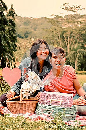 a sweet young asian couple having a picnic in the park like a lovers Stock Photo