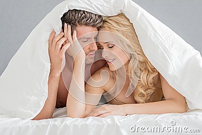 Sweet Young Couple on Bed Fashion Shoot Stock Photo