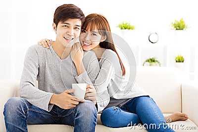 Sweet young couple sitting in sofa Stock Photo