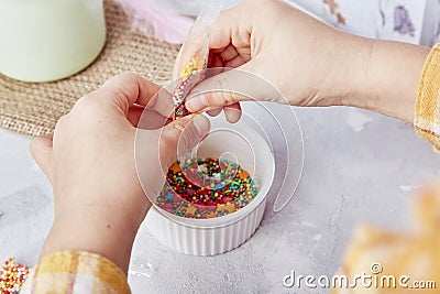 Sweetness of Easter traditions as children add sprinkles to decorate cookies close up Stock Photo