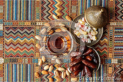 Sweets, dates and tea on a carpet Stock Photo