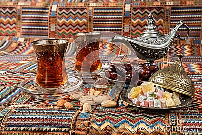 Sweets, dates and tea on a carpet Stock Photo