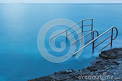 Swim ladder leading to mystic sea Stock Photo