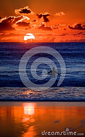Swimmer in ocean at sunset Stock Photo
