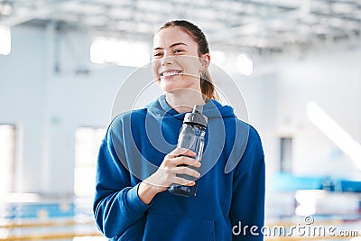 Swimmer, sports of happy woman drinking water to relax after exercise, workout or training on break. Hydrate, athlete Stock Photo