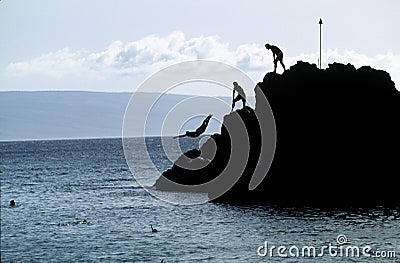 Swimmers Diving from A Rock Stock Photo