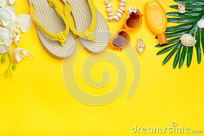 Swimming accessories - orchid flowers, sunblock, heart - shaped glasses, flip flop, palm, shells isolated on yellow background Stock Photo