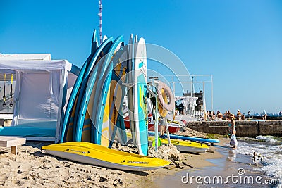 Swimming boards rental. Set of different color surf boards on the beach near the sea or ocean on a sunny day Editorial Stock Photo