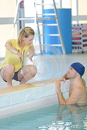 Swimming coach advising swimmer in pool Stock Photo